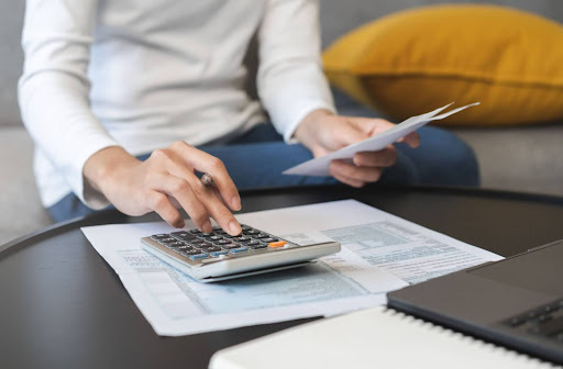 A woman computing her tax deductibles using a calculator.