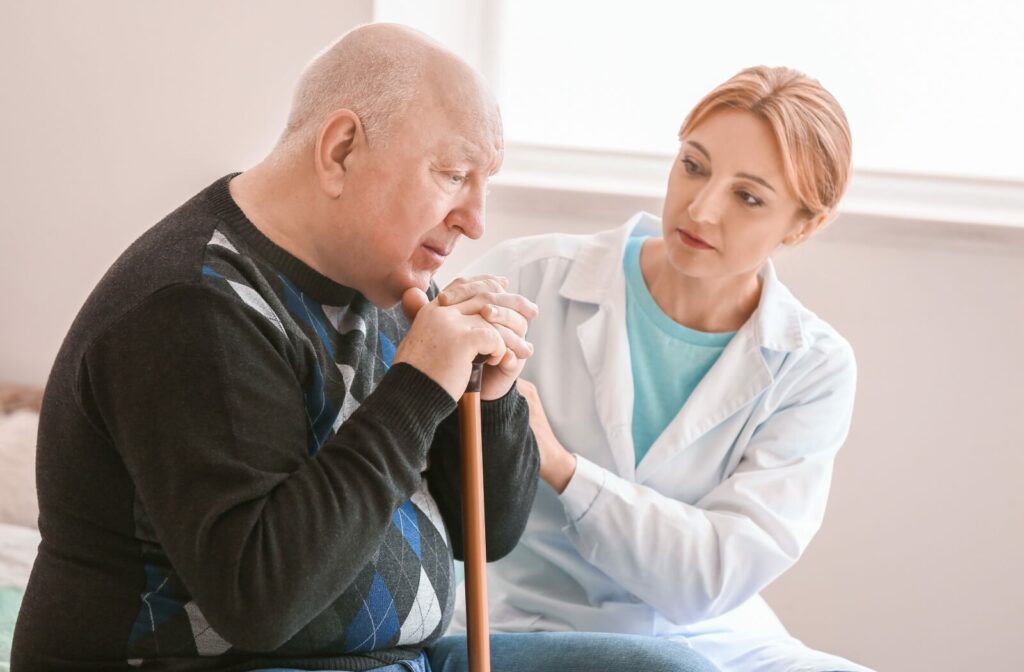 A memory care team member showing concern over an older adult male with memory impairment.
