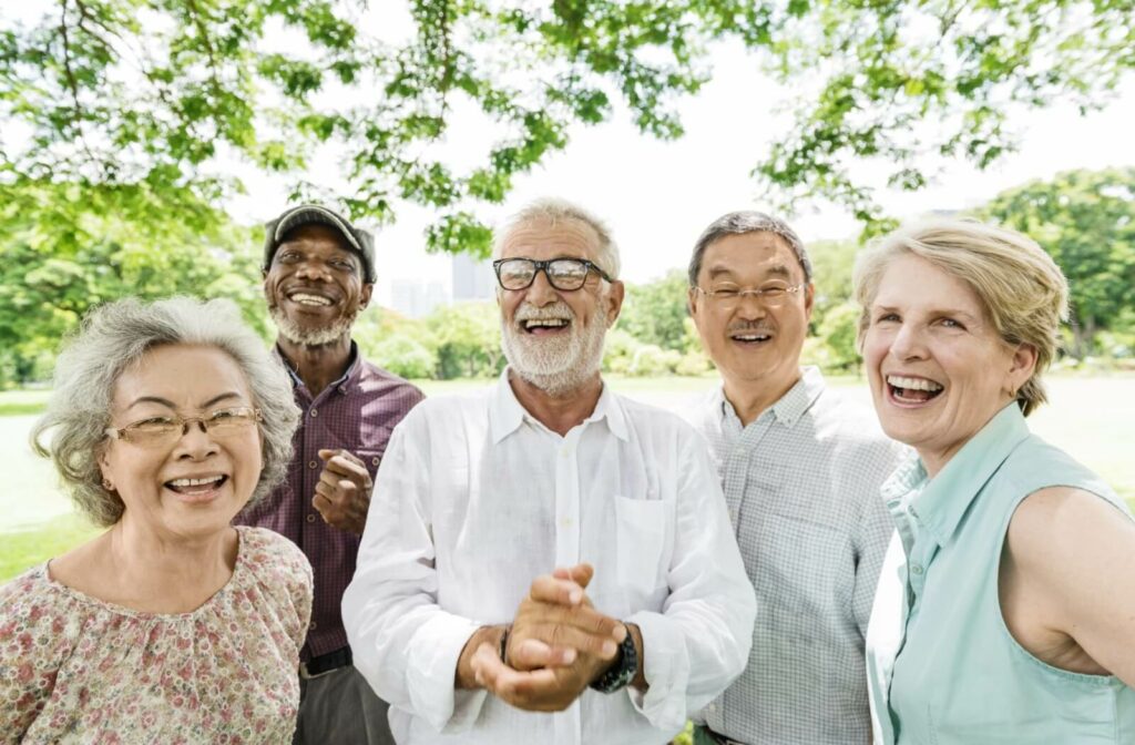 A group of older adults enjoying social time outdoors in an independent living community.